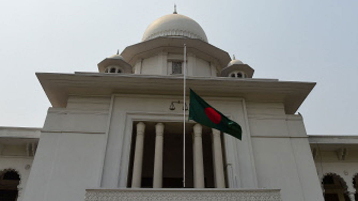 The national flag is seen flown at half mast outside the High Court building in Dhaka on 15 March 2018, as a gesture of mourning for victims of the US-Bangla Airlines plane crash in Kathmandu. Photo: AFP