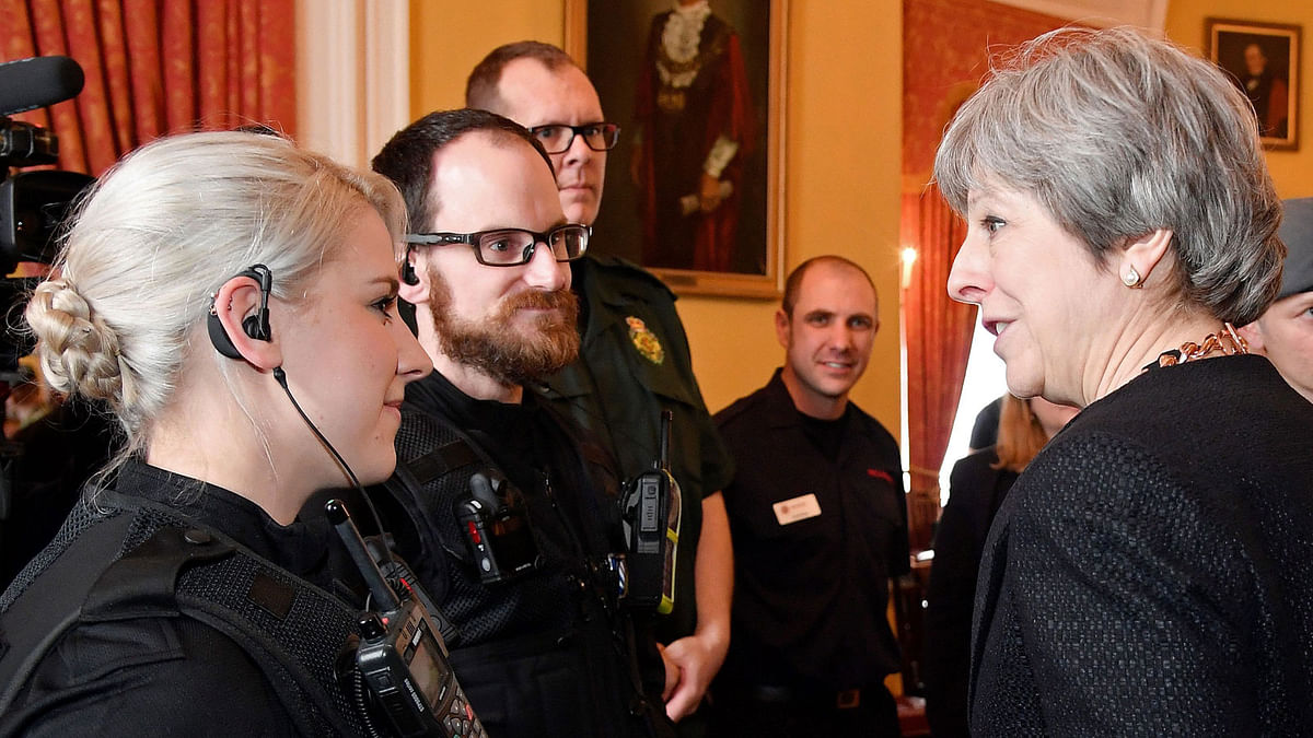 British prime minister Theresa May talks with members of the emergency services during her visit to Salisbury, southern England, on 15 March 2018, as she was shown the areas where former Russian double agent Sergei Skripal and his daughter Yulia went to, and were discovered at, following an apparent nerve agent attack on 4 March. AFP