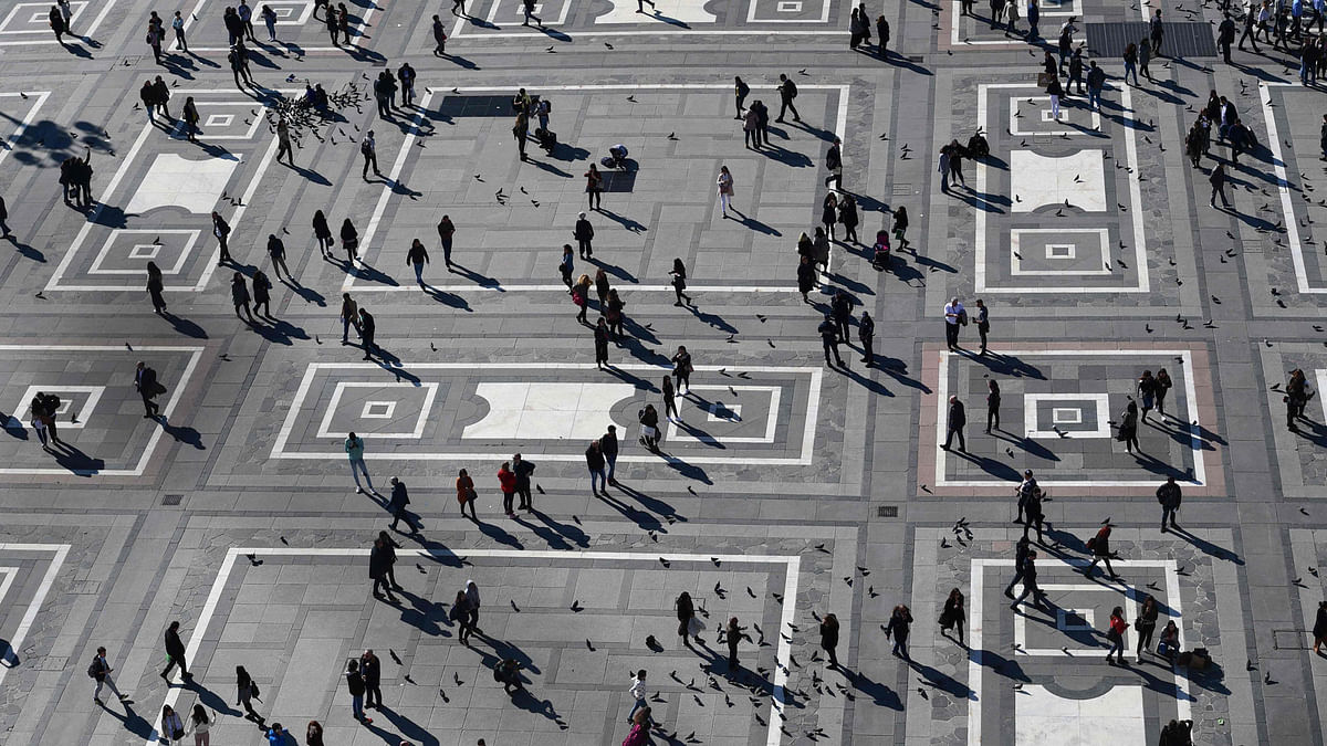 This picture taken from the roof of the Duomo in Milan on 14 March shows people walking across Duomo square. AFP