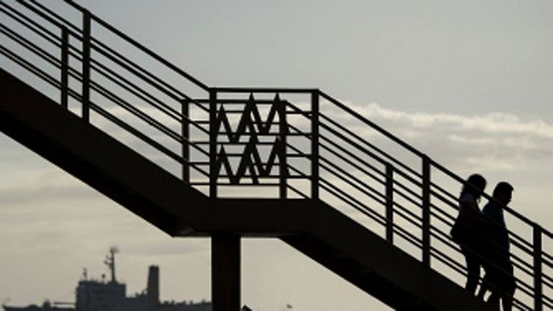 This photo taken on March 1, 2018 shows a couple crossing a footbridge at Manila Bay. Photo : AFP