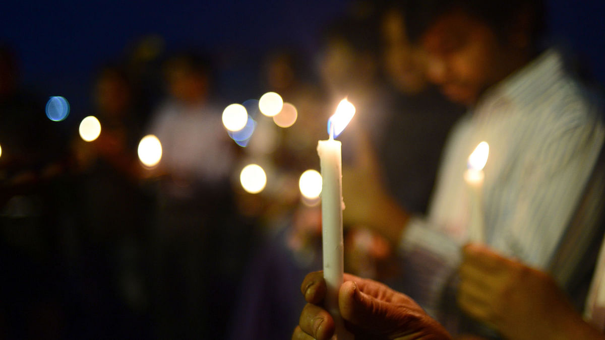 Members of Society of the Deaf and Sign Language Users (SDSL) and residents light candle during a vigil for SDSL founder Rafiq Zaman, his wife and son, who were killed in the US-Bangla plane crash in Kathmandu, in Dhaka on 25 March, 2018. Photo: AFP