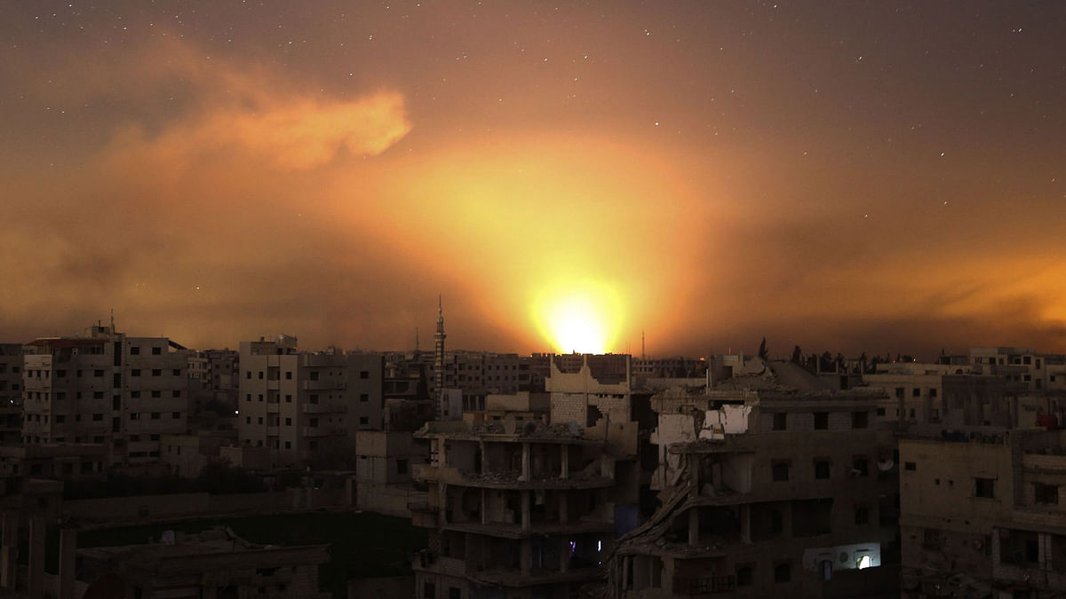 A general view shows explosions lighting the sky following regime air strikes on Arbin, in the rebel enclave of Eastern Ghouta on the outskirts of Damascus on 12 March. AFP