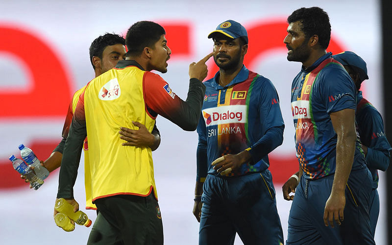 Nurul Hasan (2L) exchanges words with Sri Lanka`s skipper Thisara Perera (R) during the sixth Twenty20 (T20) international cricket match between Bangladesh and Sri Lanka of the tri-nation Nidahas Trophy at the R Premadasa stadium in Colombo on 16 March, 2018. Photo: AFP