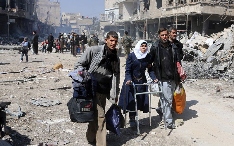 A Syrian girl uses a walker as she evacuates with other civilians from the town of Jisreen in the southern Eastern Ghouta, on the eastern outskirts of the capital Damascus, on the way to areas under government control on Saturday. Photo: AFP
