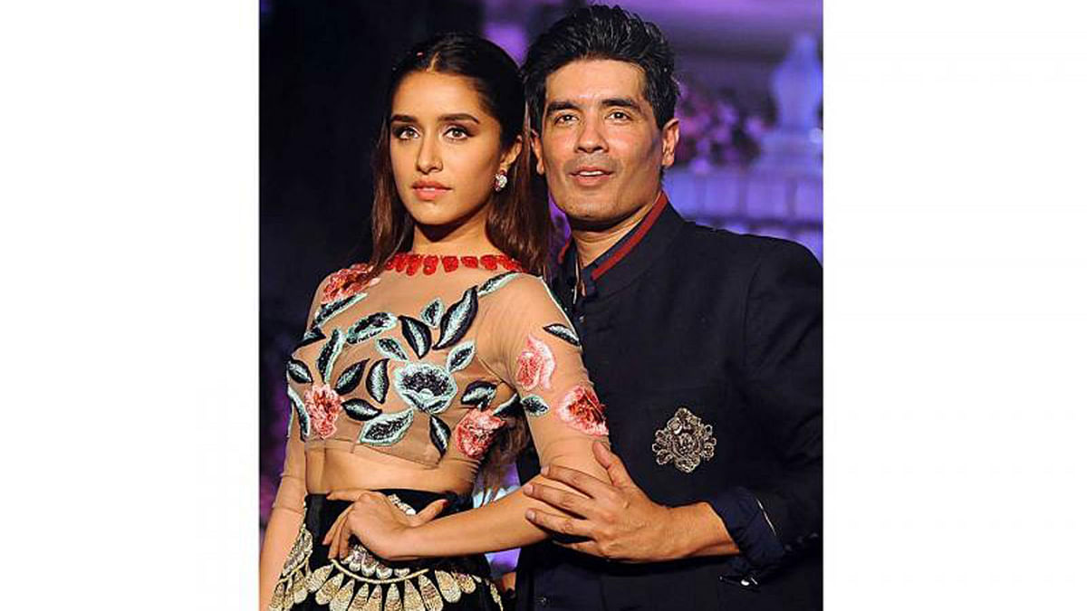 Indian Bollywood actress Shradha Kapoor (L) showcases a creation by designer Manish Malhotra (R) during the Lakme Fashion Week (LFW) Winter/Festive 2016 in Mumbai on 24 August 2016. Photo: AFP