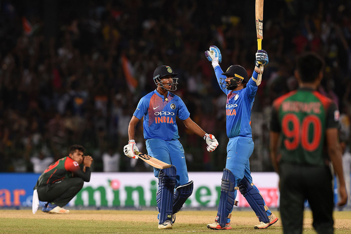 Dinesh Karthik (2nd R) and Washington Sundar (2nd L) react after the former hit a six in the final ball while dejected Bangladesh players look on. AFP