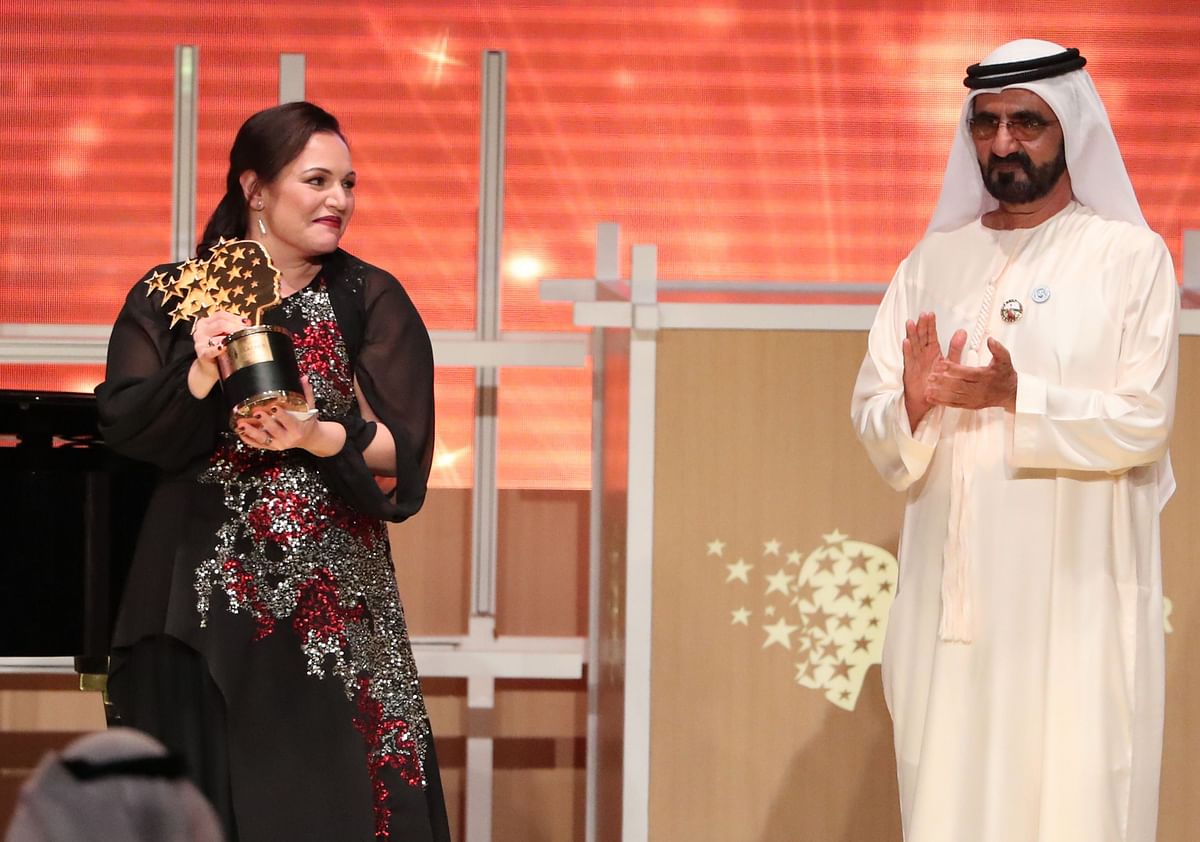 British teacher Andria Zafirakou (L) receives the `Global Teacher Prize` from Sheikh Mohammed bin Rashid al-Maktoum, vice-president and prime minister of the UAE and Ruler of Dubai during an award ceremony in Dubai on 18 March, 2018. Photo: AFP