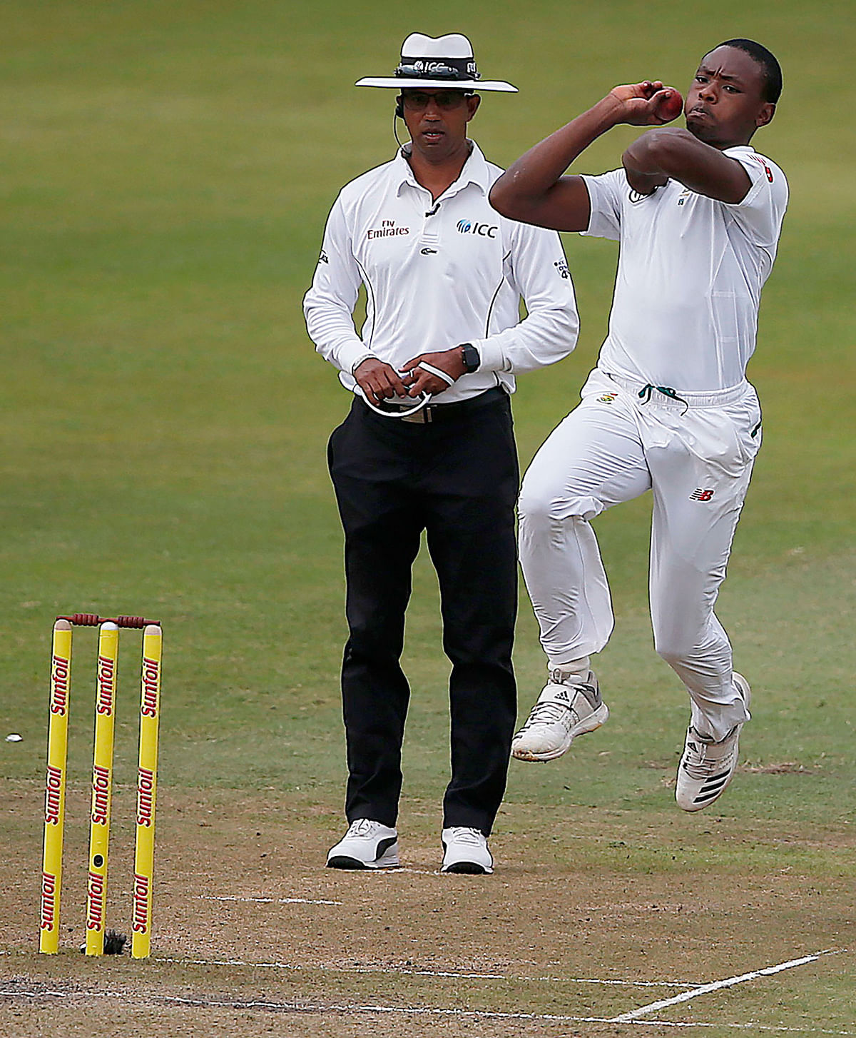 In this file photo taken on March 2, 2018 South African bowler Kagiso Rabada (R) is watched by umpire Kumar Dharmasena as he delivers a ball during play on the second day two of the first Test cricket match between South Africa and Australia at The Kingsmead Stadium in Durban. AFP