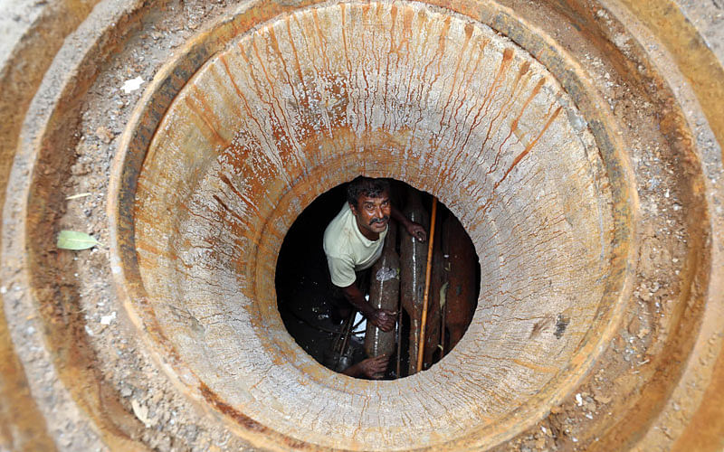 Workers repair the T&T connection after descending 10-feet deep in a manhole in Mirzapur area of Chittagong on 19 March. Photo: Jewel Shil