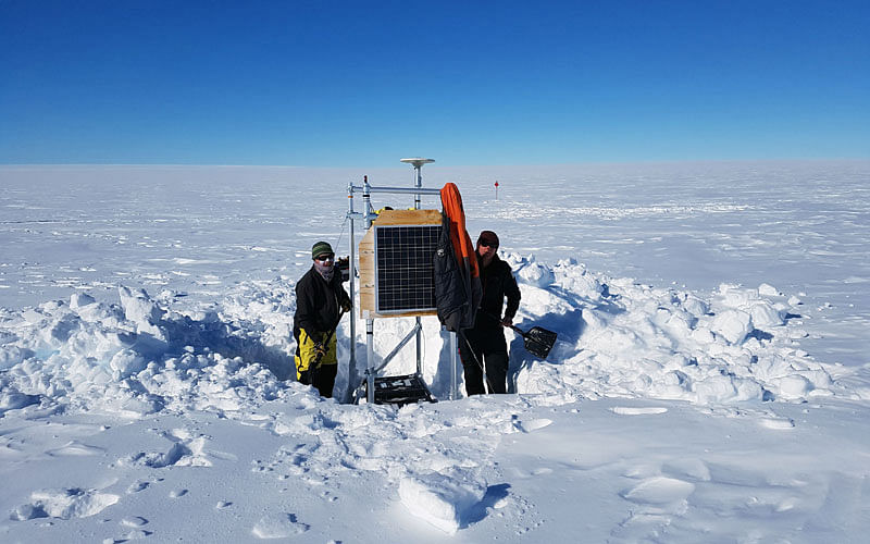 This handout picture taken on 21 December, 2017 by Ben Galton-Fenzi and released by the Australian Antarctic Division on 20 March, 2018 shows scientists setting up equipment on Totten Glacier to measure glacial flow speed and surface elevation. Photo: AFP