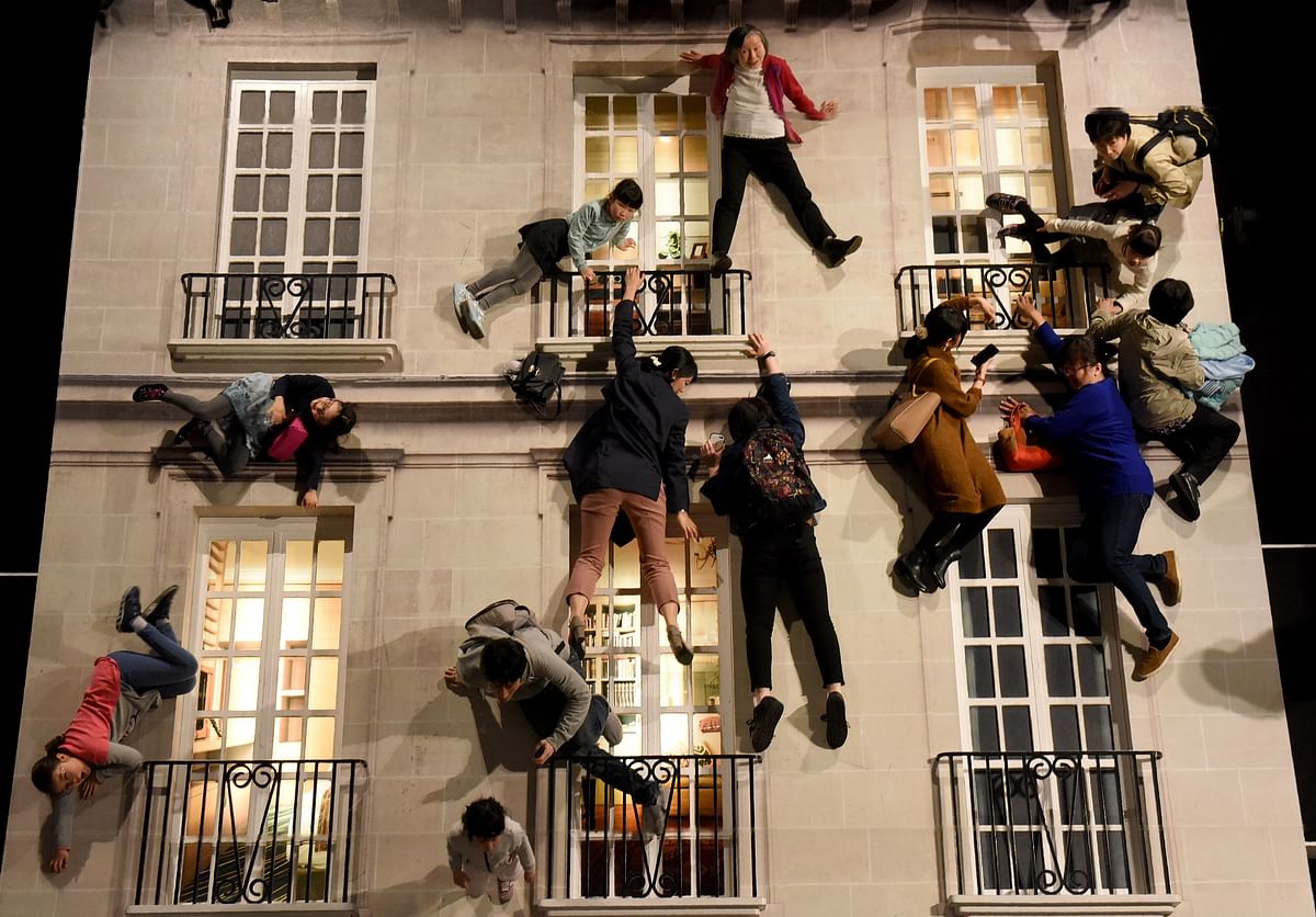 In this picture taken on 4 March 2018, people experience the `Building` installation during the exhibition `Seeing and Believing` by Argentine artist Leandro Erlich at Mori Art Museum in Tokyo. Photo: AFP