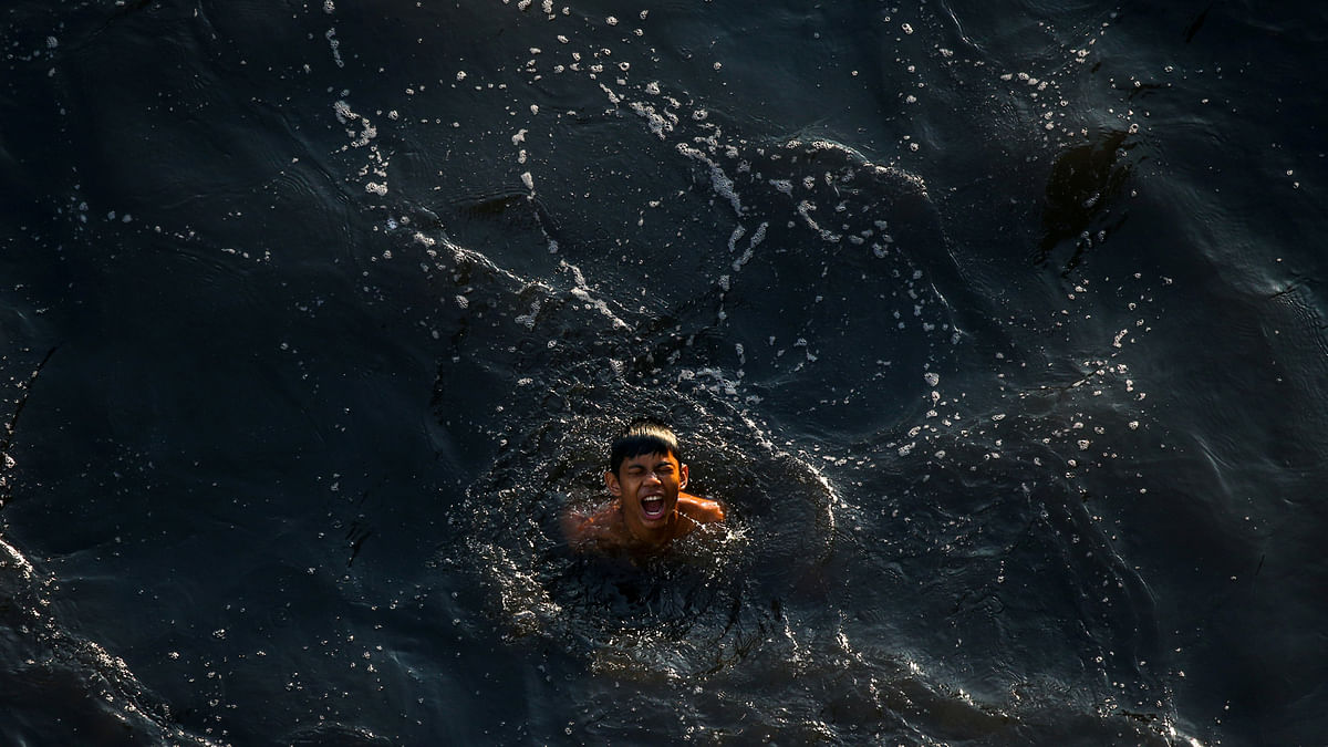 A boy swims in the polluted water of a canal in Bangkok, Thailand on 20 March. Photo: Reuters