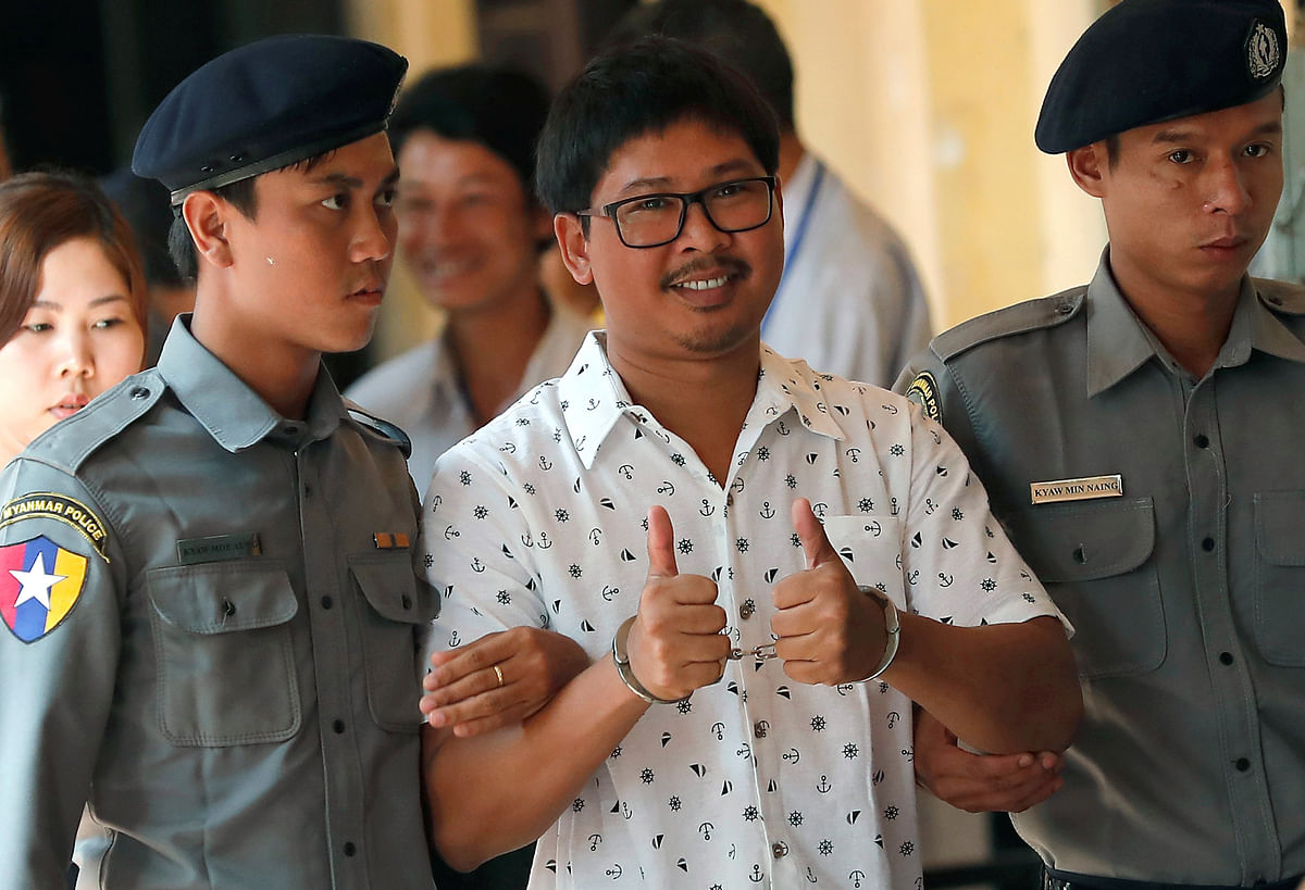 Detained Reuters journalist Wa Lone is escorted by police as he arrives for a court hearing in Yangon, Myanmar 21 March 2018. Reuters