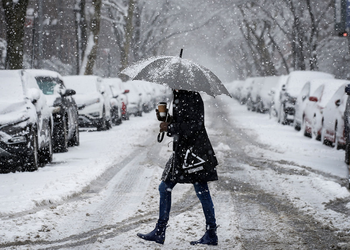 A woman walks in the snow during a winter nor<SNG-QTS>easter storm in the Brooklyn borough of New York, US, 21 March. Reuters