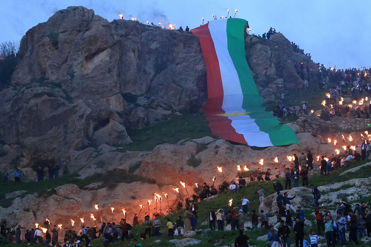 Iraqi Kurdish people carry fire torches up a mountain, as they celebrate Newroz Day, a festival marking their spring and new year, in the town of Akra, Iraq on 20 March. Reuters