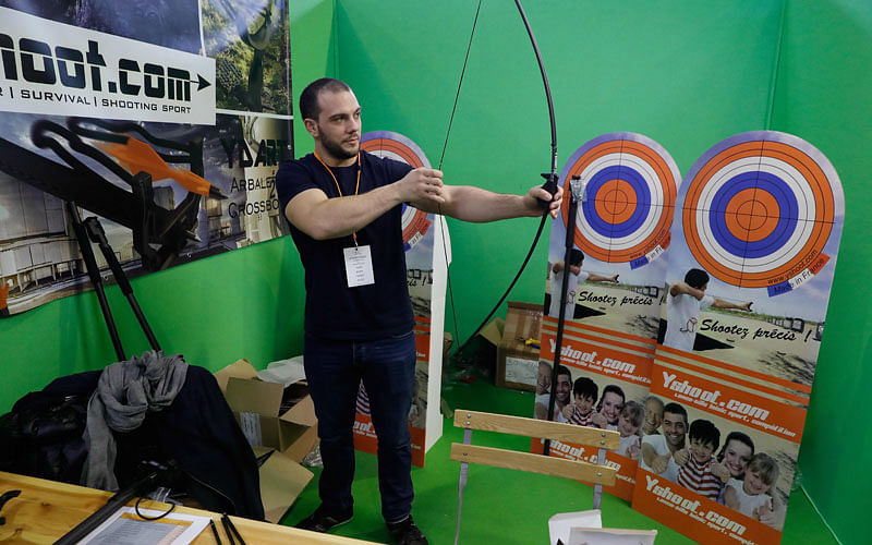 A salesman shows how to use a bow at the Survival Expo on 23 March in Paris. Photo: AFP