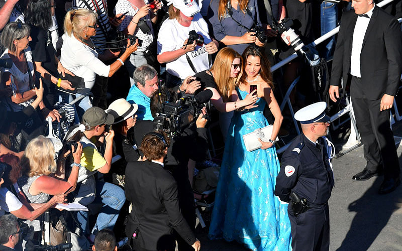 Chinese-Malaysian actress Michelle Yeoh poses for selfies as she arrives during the opening ceremony of the 70th Cannes Film Festival in Cannes, southern France on on 17 May 2017. Photo: AFP