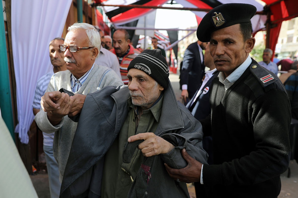 An elderly man is helped as he arrives to cast his vote outside a polling station during the presidential election in Cairo, Egypt on 26 March. Photo: Reuters