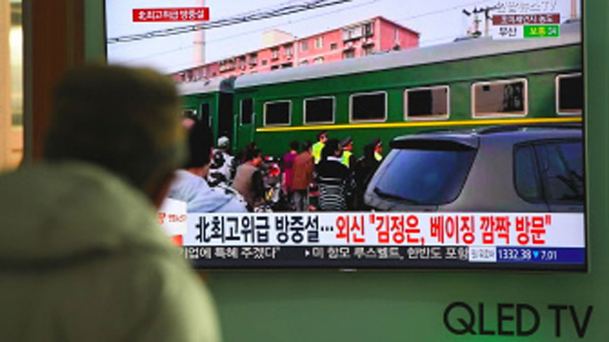A man watches a television news report about a suspected visit to China by North Korean leader Kim Jong Un, at a railway station in Seoul on March 27, 2018. Photo : AFP