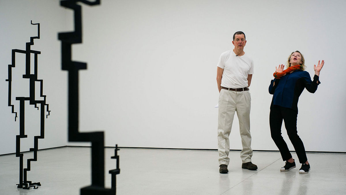 British sculptor Antony Gormley (2nd R) and Andrea Schlieker, director of commissions and special projects at White Cube, stand next to his sculptures `Signal`, 2017, (L) and `Spall` 2017, (foreground) as they speak about his exhibition. AFP