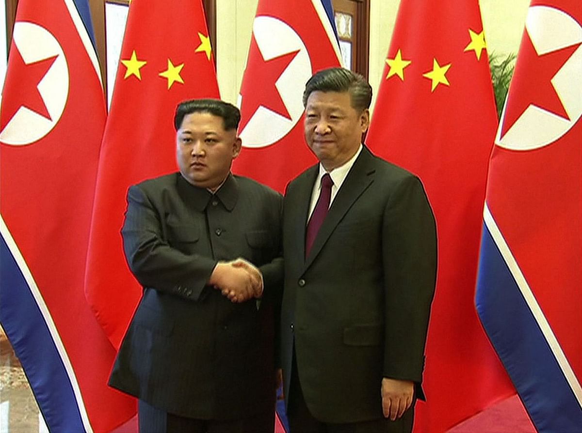 Chinese President Xi Jinping ® and North Korean leader Kim Jong Un shaking hands during their meeting in Beijing on Tuesday. Photo: AFP