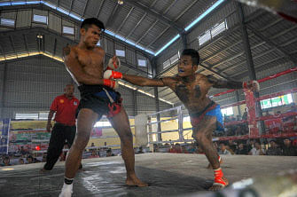 In this photograph taken on March 27, 2018, Myanmar fighters Than Zaw Htay (L) and Tun Tun (R) battle during a ground-breaking Lethwei competition marking Armed Forces Day in the town of Maungdaw in Rakhine state. Photo : AFP