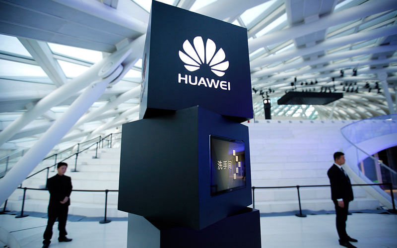 In this May 26, 2016 photo, security personnel stand near a pillar with the Huawei logo at a launch event for the Huawei MateBook in Beijing. Photo: AP