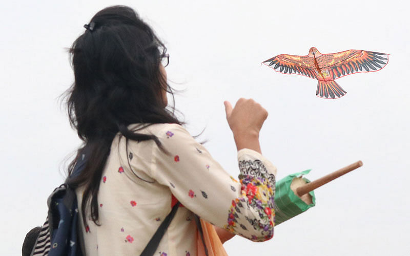 A girl flies a kite in the kite festival at Lalon Shah Mancha in Rajshahi. Photo: Shahidul Islam