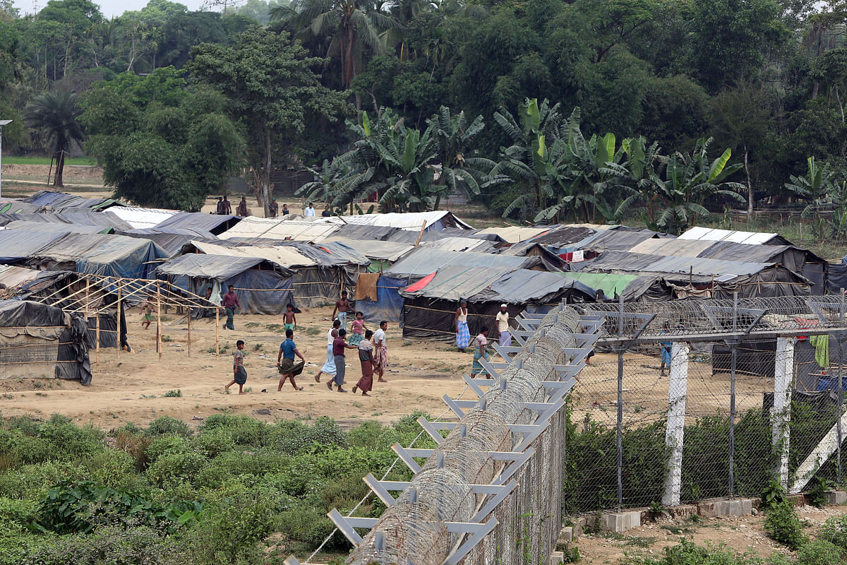Rohingya people who fled from their towns after the violence in the state of Rakhine, are seen behind a fence on the border line outside Maungdaw, Myanmar on 31 March 2018. Reuters