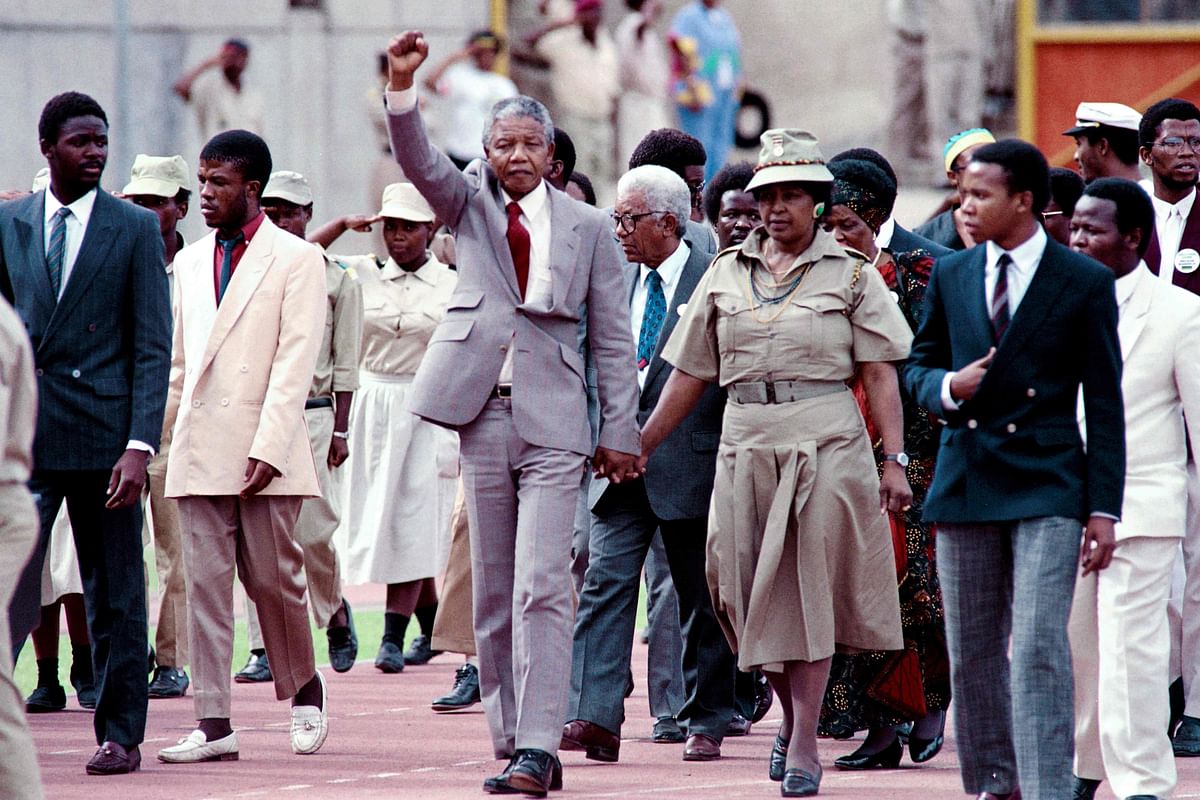 In this file photo taken on 25 February 1990 Anti-apartheid leader and African National Congress (ANC) member Nelson Mandela (C) raises clenched fist, accompanied by his wife Winnie Mandela (R), as he arrives to address mass rally, a few days after his release from jail, in the conservative Afrikaaner town of Bloemfontein, where ANC was formed 75 years ago. AFP