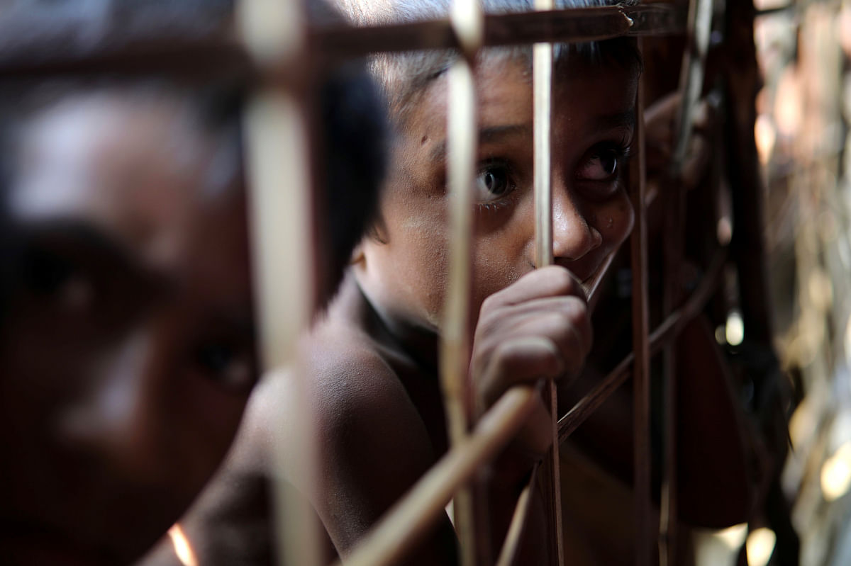 Rohingya refugee child looks through the fence at a refugee camp in Cox`s Bazar, Bangladesh 22 March 2018. Reuters
