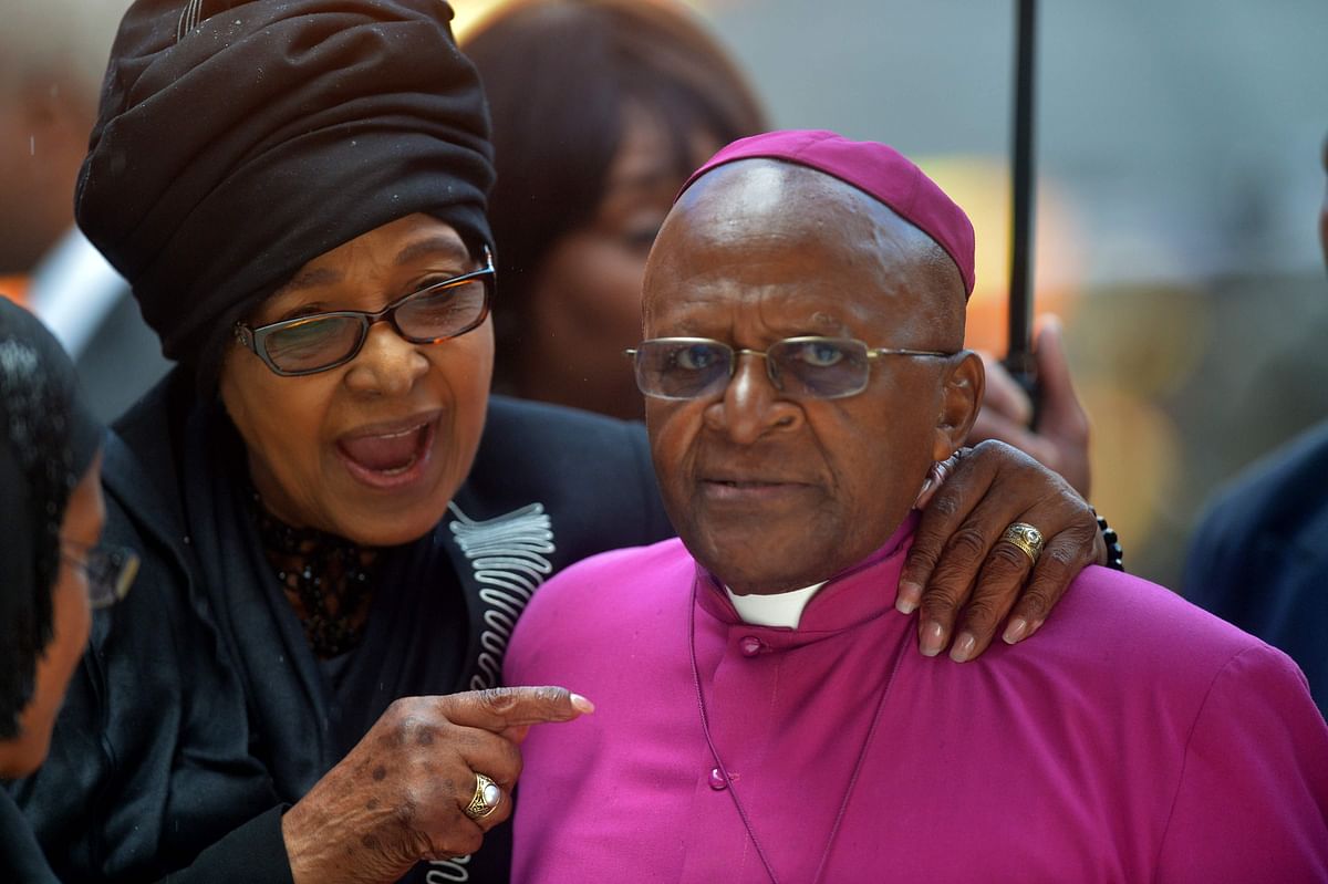 In this file photo taken on 10 December 2013 Nelson Mandela`s former wife Winnie Madikizela-Mandela speaks with South African Archbishop and Honorary Elders Desmond Tutu during the memorial service of South African former president Nelson Mandela at the FNB Stadium (Soccer City) in Johannesburg. AFP