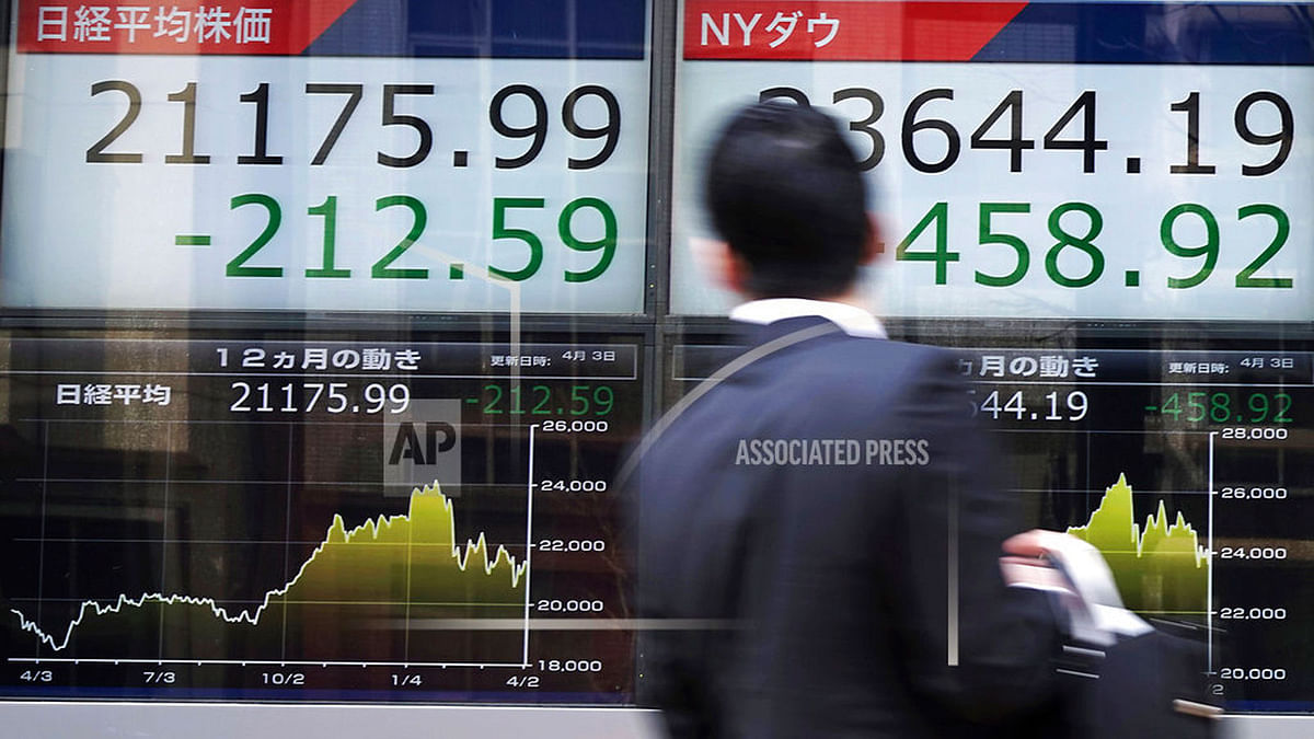 A man looks an electronic stock board showing Japan`s Nikkei 225 index and New York Dow index at a securities firm in Tokyo, Tuesday, April 3, 2018. Asian stocks have fallen for a second day amid jitters about U.S.-Chinese trade tensions and mounting scrutiny of technology companies Photo : AP