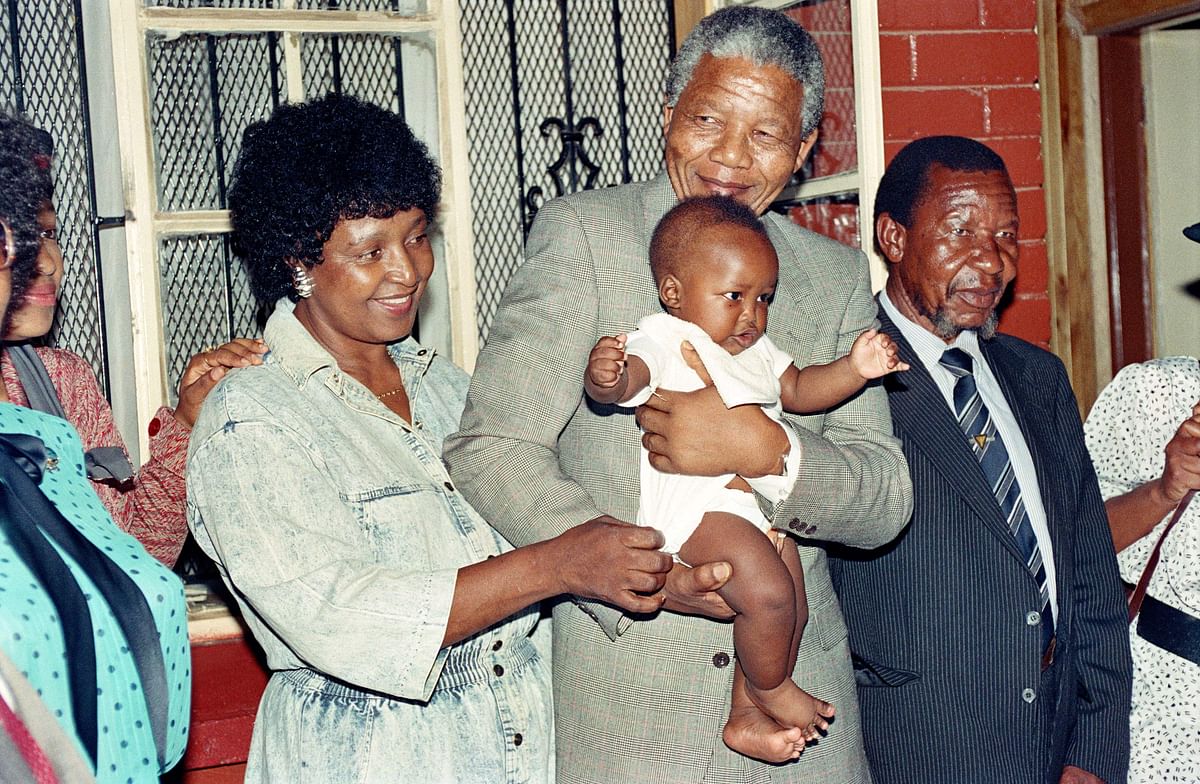 In this file photo taken on 21 February 1990 Anti-apartheid leader and African National Congress (ANC) member Nelson Mandela and his wife Winnie play with their grandchild Bambata at their Soweto home. AFP