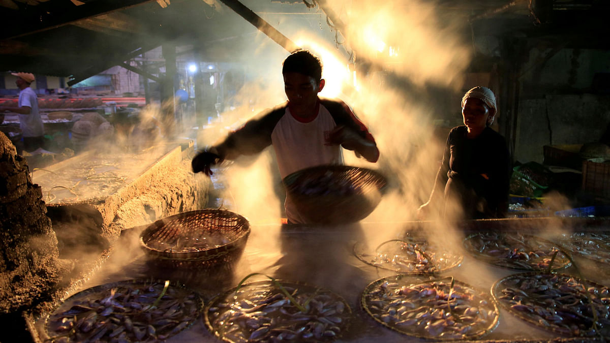 A worker is seen marinating fish at Cilincing district in Jakarta, Indonesia on 5 April. Photo: Reuters