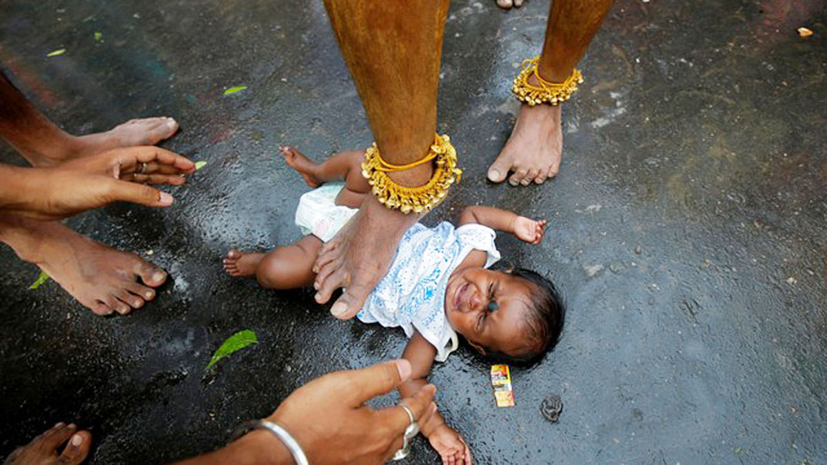 A Hindu holy man touches an infant with his foot as part of a ritual to bless her during a religious procession to mark Bhel Bhel festival dedicated to Hindu goddess Muthumariamman in Bandel town in the eastern state of West Bengal, India, April 6, 2018 Photo : Reuters