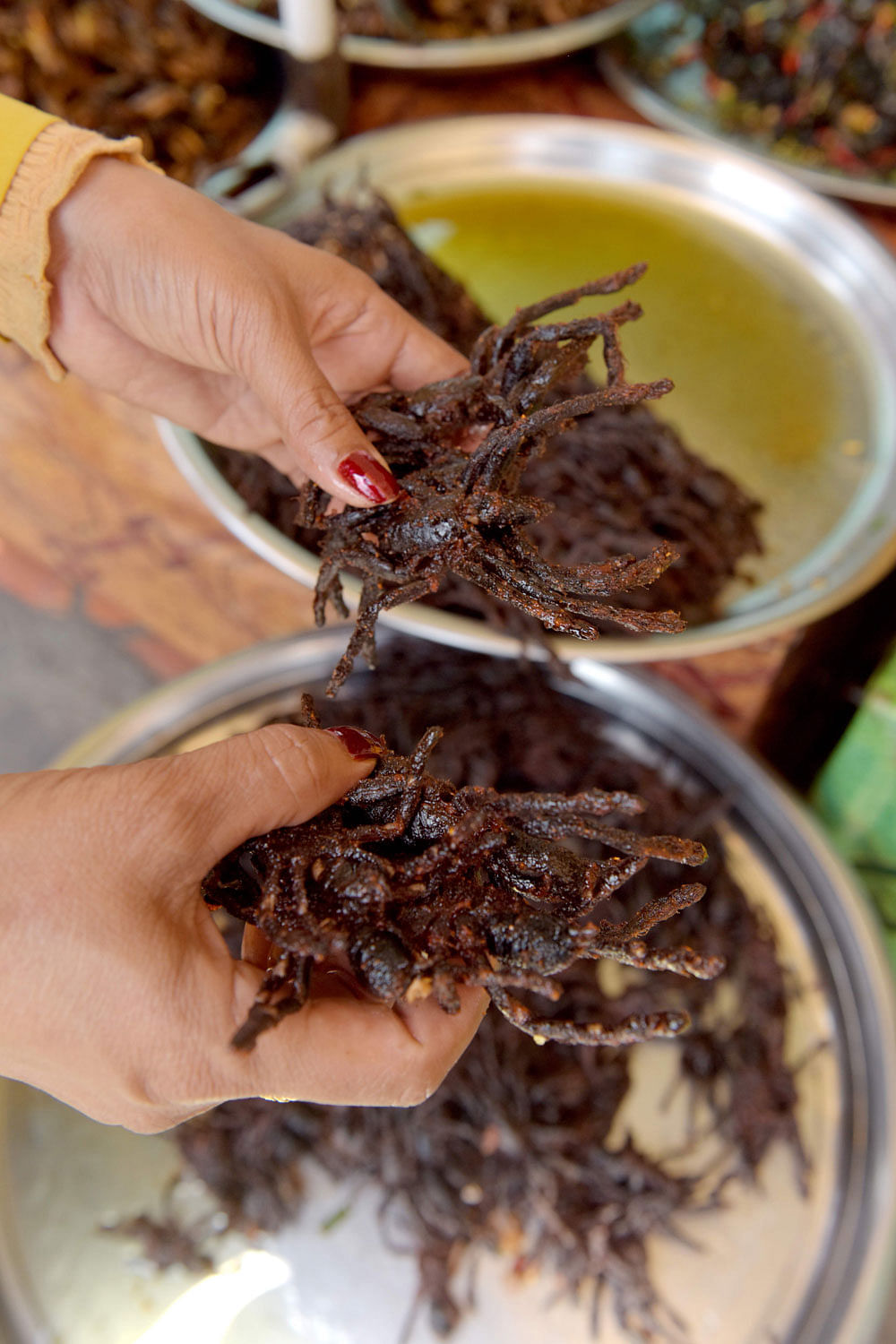 This photo taken on 14 March 2018 shows a Cambodian vendor preparing fried tarantulas for sale at Skun town in Kampong Cham province. While a plate piled high with hairy, palm-sized tarantulas is the stuff of nightmares for some, these garlic fried spiders are a coveted treat in Cambodia, where the only fear is that they may soon vanish due to deforestation and unchecked hunting. Photo: AFP