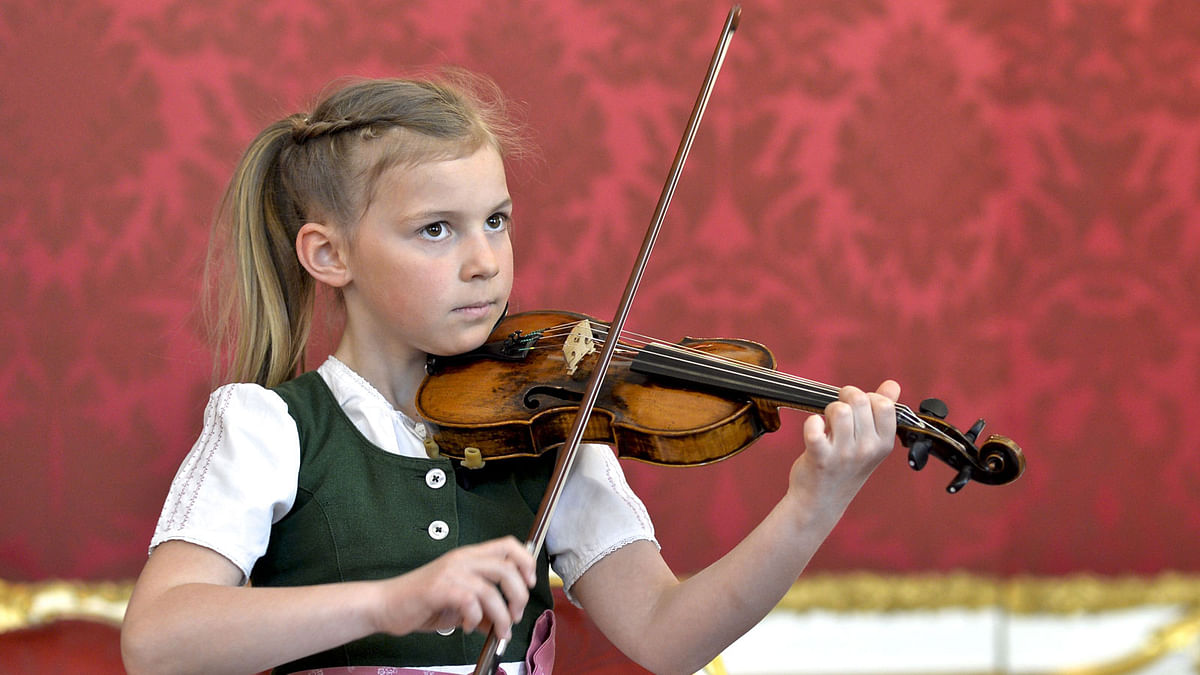 Seven year old Anna Cacilia Pfoess plays a violin used by Mozart in front of Austrian President Alexander Van der Bellen (not in picture) at the Chancellery in Vienna, Austria, 6 April, 2018. Photo: AFP