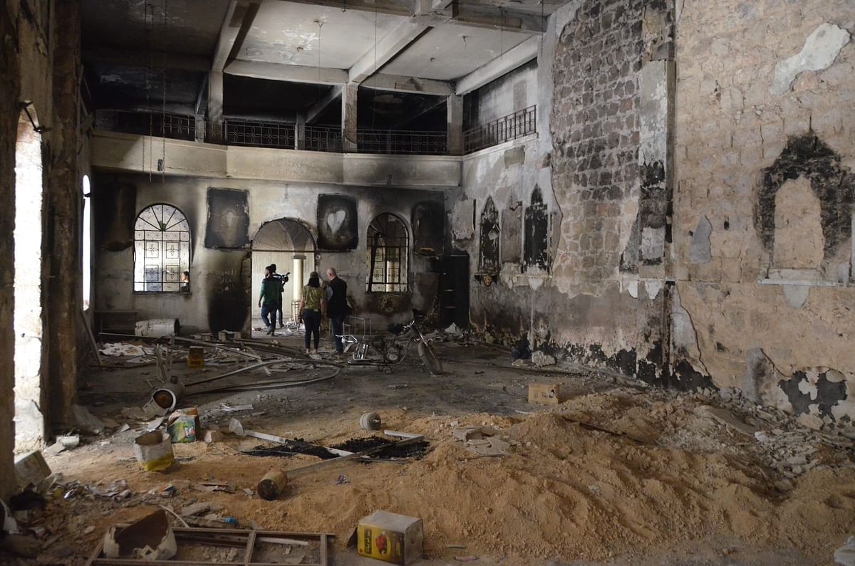 Journalists walking inside a destroyed Church in Arbin in eastern Ghouta on 6 April 2018. Photo: AFP