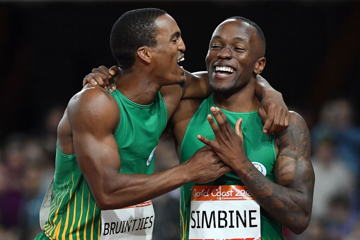 South Africa’s Henricho Bruintjies (silver) and South Africa’s Akani Simbine (gold) celebrate after the athletics men’s 100m final during the 2018 Gold Coast Commonwealth Games at the Carrara Stadium on the Gold Coast on Monday. Photo: AFP