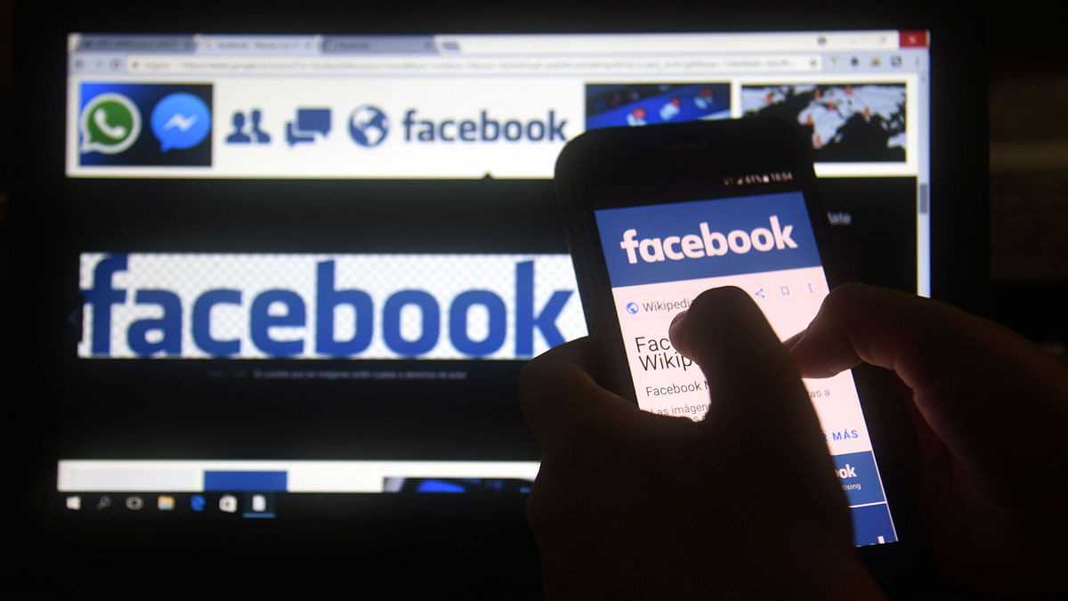 In this file photo taken on 22 March, 2018 a cellphone and a computer screen display the logo of the social networking site Facebook in Asuncion. Photo: AFP