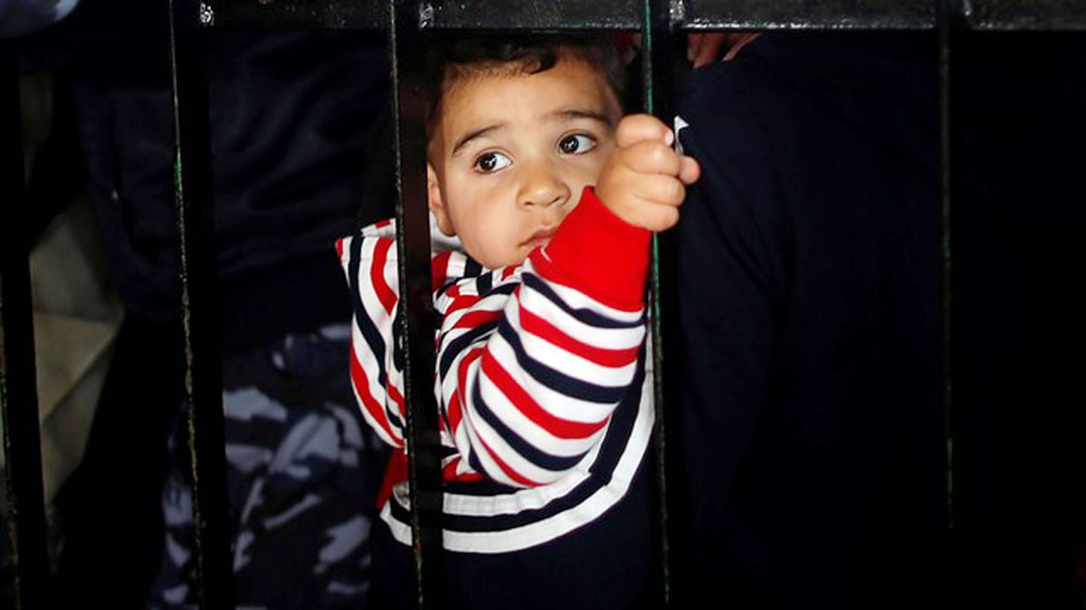 A Palestinian boy waits with his family to travel into Egypt, after the Rafah border crossing was opened for three days for humanitarian cases, in the southern Gaza Strip April 12, 2018. Photo : Reuters