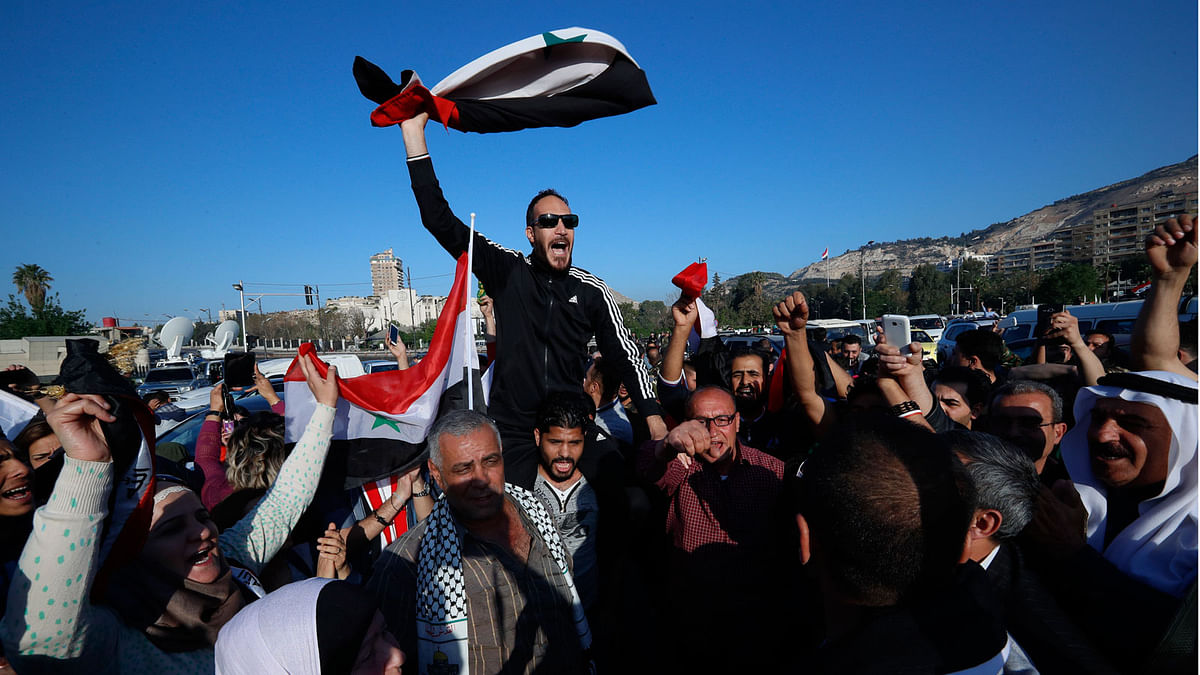 Syrian government supporters chant slogans against US president Trump during demonstrations following a wave of US, British and French military strikes to punish president Bashar Assad for suspected chemical attack against civilians, in Damascus, Syria on 14 April. Photo: AFP