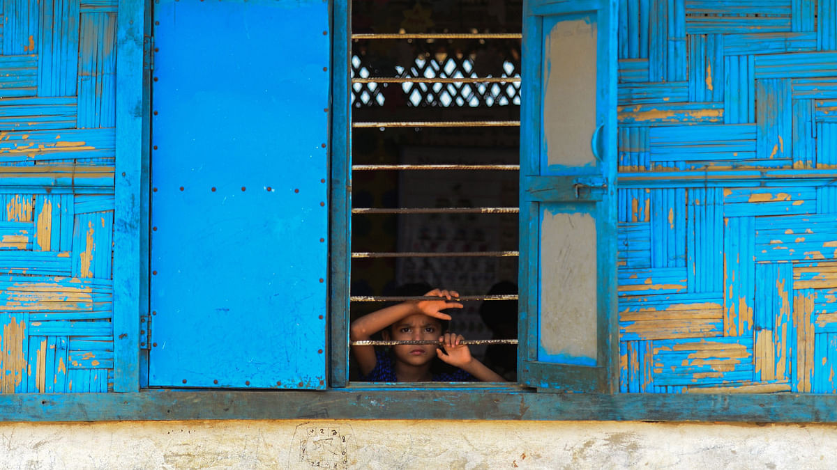 In this file photo taken on 5 April 2018 a Rohingya refugee looks out from a school window at Kutupalong refugee camp in Bangladesh's Ukhia district. AFP