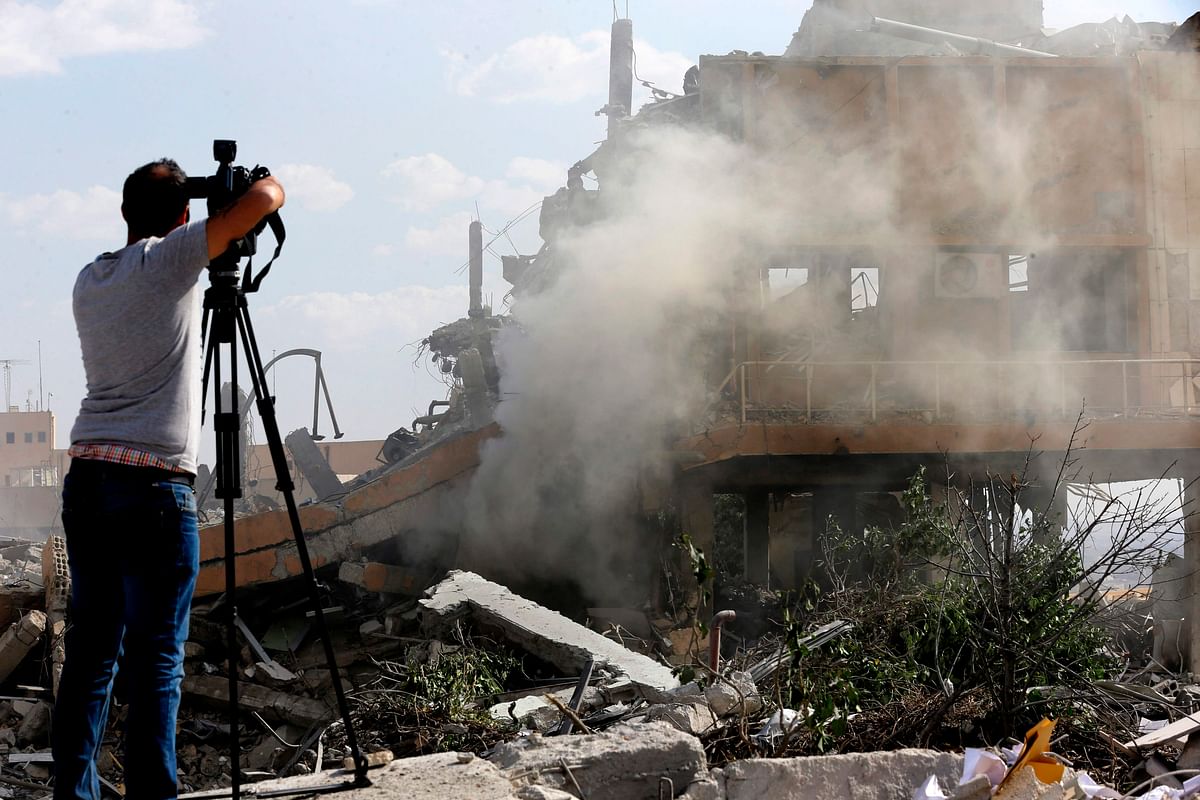 A journalist films the wreckage of a building described as part of the Scientific Studies and Research Centre (SSRC) compound in the Barzeh district, north of Damascus, during a press tour organised by the Syrian information ministry on Saturday. Photo: AFP