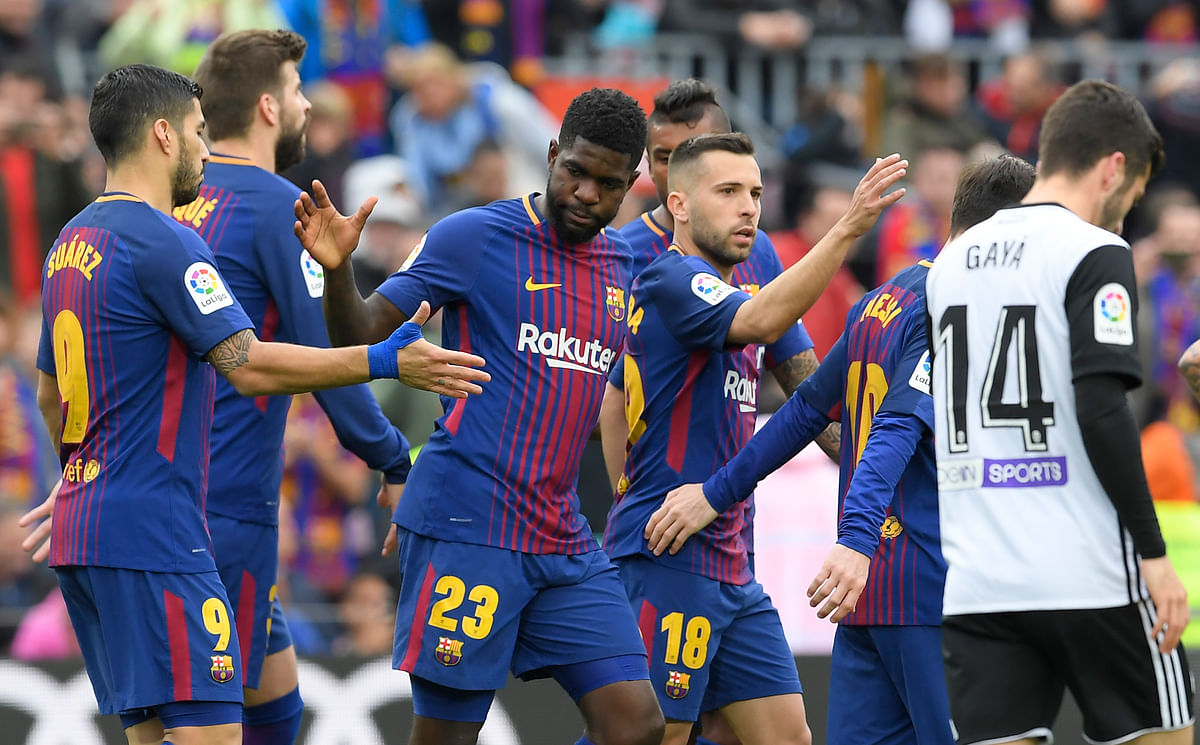 Barcelona’s French defender Samuel Umtiti © celebrates scoring a goal with teammates during the Spanish league footbal match between FC Barcelona and Valencia CF at the Camp Nou stadium in Barcelona on Saturday. Photo: AFP