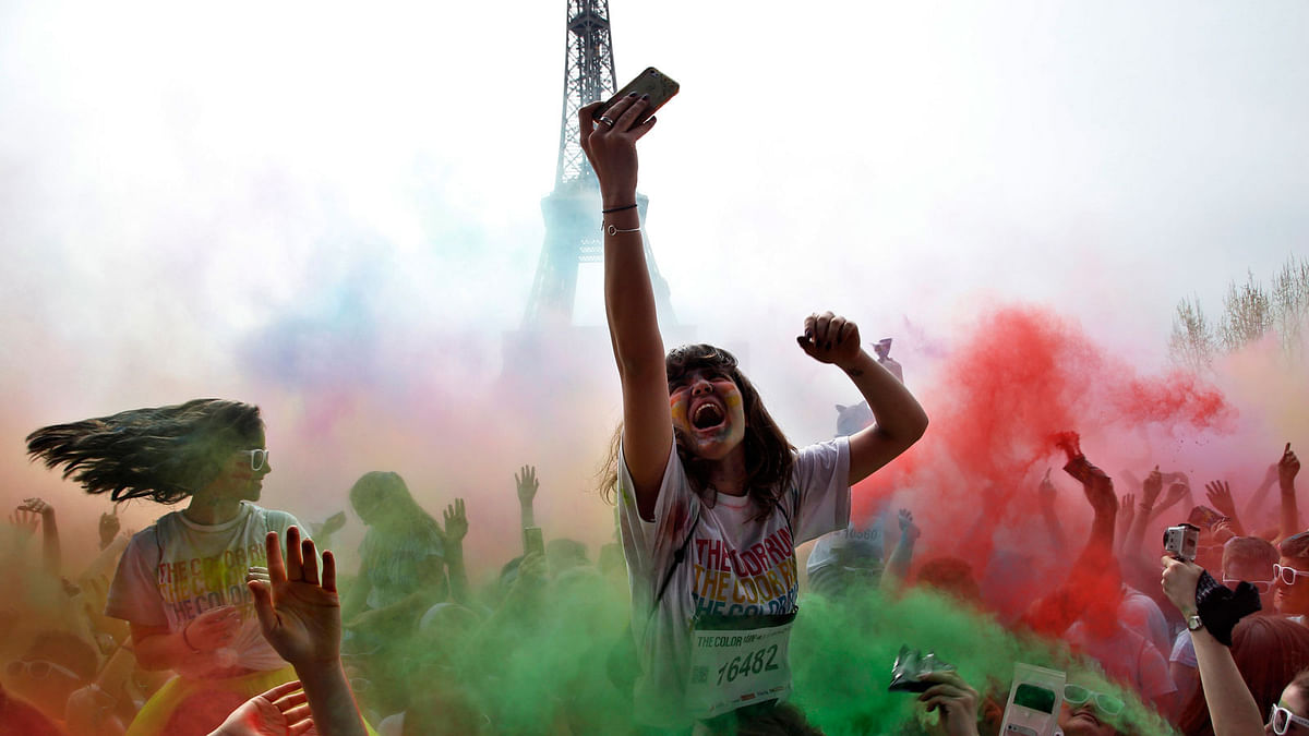 People celebrate at the end of the Colour Run 2018 race, in front of the Eiffel Tower in Paris on 15 April.  Photo: AP