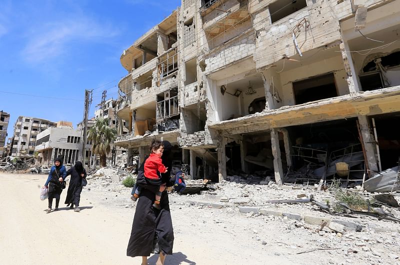 Syrians walk down the street past destroyed buildings in Douma on the outskirts of Damascus on Monday during an organised media tour after the Syrian army declared that all anti-regime forces have left Eastern Ghouta, following a blistering two month offensive on the rebel enclave. Photo: AFP