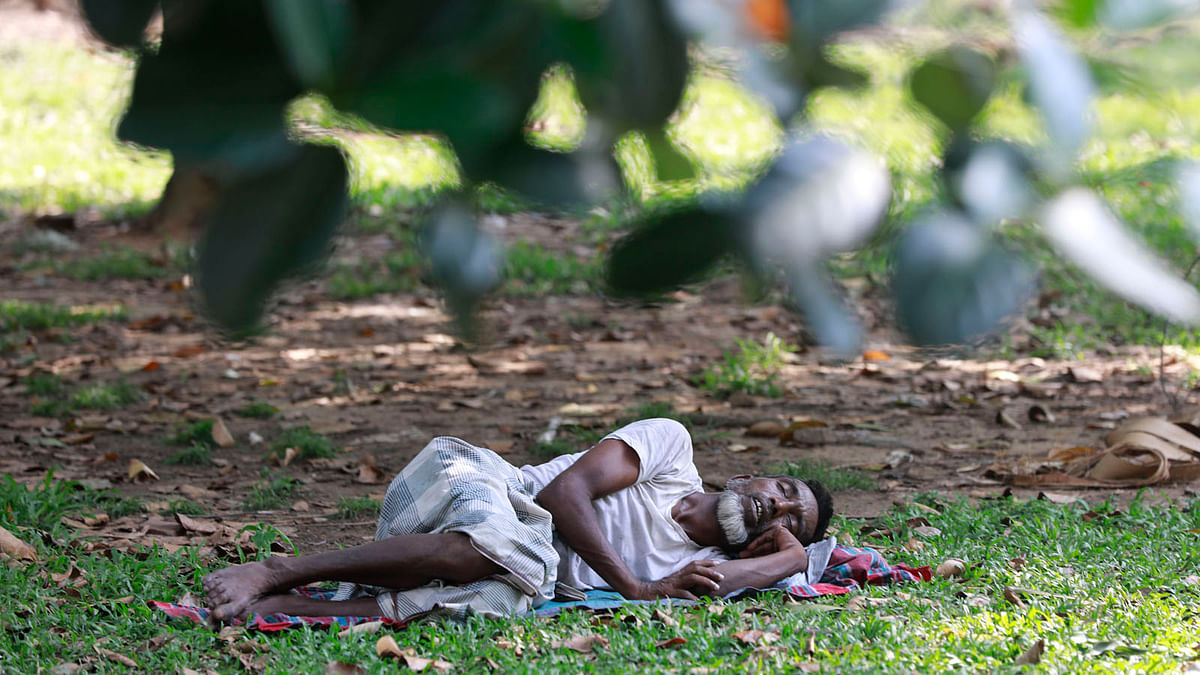 A man takes a nap in the open air beneath a tree at Suhrawardi Udyan in Dhaka on 16 April. Photo: Suvra Kanti Das