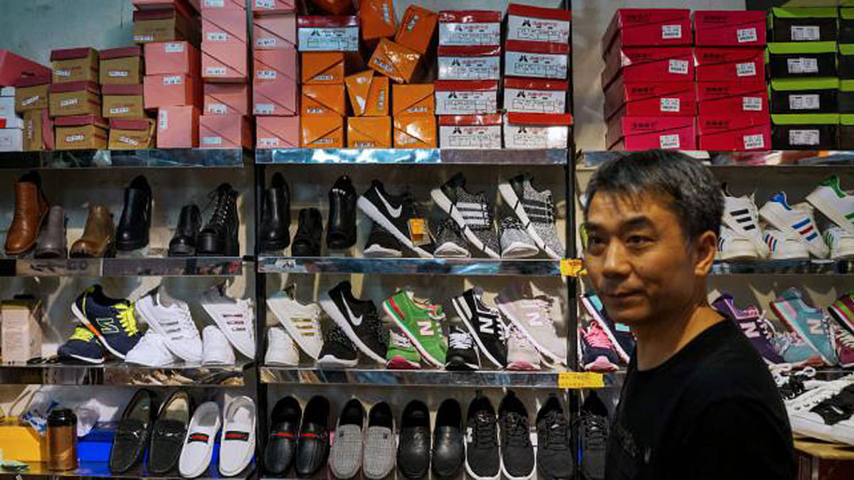 A Chinese salesman looks on as he sells copies of various American footwear brands. AFP